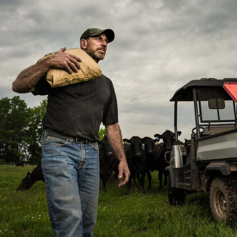 farmer carrying bag over shoulder