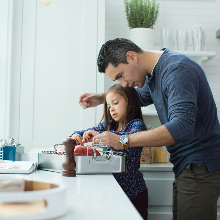 man helping daughter in kitchen