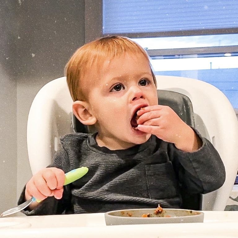 toddler eating in a highchair